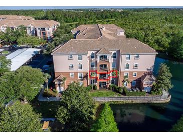 Beautiful multi-level condo building with lush landscaping and waterfront view at 1357 Venezia Ct # 202, Davenport, FL 33896