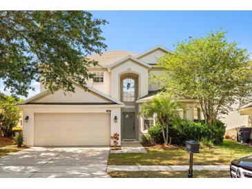 Charming two-story home with a well-manicured lawn and attached two-car garage at 206 Bonville Dr, Davenport, FL 33897