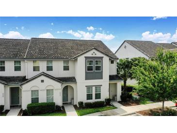 Charming two-story townhome with a well-maintained lawn, tile roof, and beautiful landscaping at 228 Captiva Dr, Davenport, FL 33896