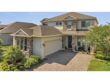Charming two-story home featuring stone accents, a spacious garage, and a beautifully paved driveway at 2348 Pearl Cider St, Orlando, FL 32824