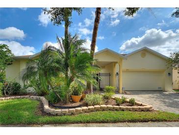 Inviting single-story home featuring a paver driveway, manicured landscaping, and a charming gated courtyard at 271 Falling Waters Dr, Kissimmee, FL 34759