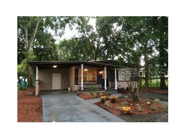 Charming single-story home with a covered carport, front porch, and well-maintained landscaping at 415 Calhoun Pl, Orlando, FL 32801