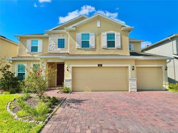 Charming home with a brick driveway, a three-car garage, and beautiful stone accents at 5019 Down Ct, St Cloud, FL 34772