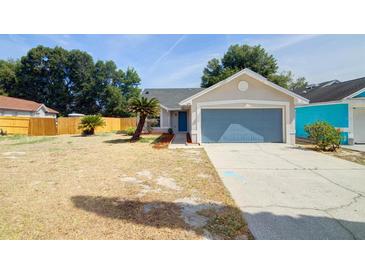 Charming home featuring an attached garage and landscaped front yard at 6593 Meritmoor Cir, Orlando, FL 32818