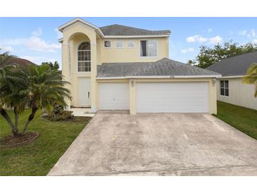 Two-story home with a three-car garage, arched entryway, and well-manicured lawn at 6714 Bouganvillea Crescent Dr, Orlando, FL 32809