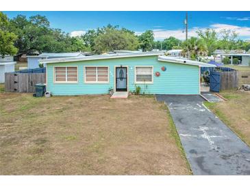 Charming single story home featuring a tidy front yard, paved driveway, and unique sky blue exterior at 690 W Pearl St, Bartow, FL 33830