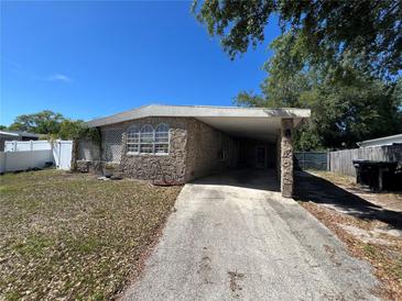 Charming stone-clad home with a covered carport and well-maintained front yard at 6937 Gibraltar Rd, Orlando, FL 32822