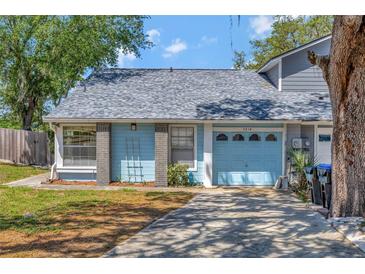 Charming single Gathering home featuring a blue exterior, a garage, and a well-maintained front yard at 7218 Alston Ct, Orlando, FL 32835