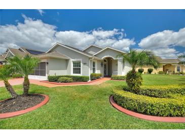 Charming single-story home with lush landscaping, healthy green lawn and inviting entryway and walkway at 801 Ashton Dr, Davenport, FL 33837