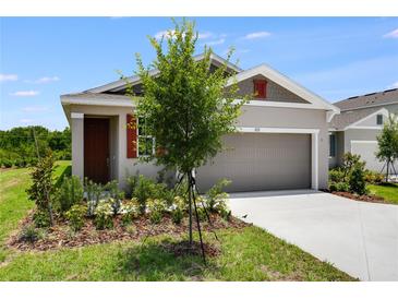 Charming single-story home with a two-car garage and well-manicured lawn, offering great curb appeal at 832 Lake Dell Rd, Dundee, FL 33838
