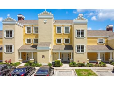 Beautiful townhouse exterior with yellow siding and white trim, inviting curb appeal and well-maintained landscaping at 1311 Seven Eagles Ct # 202, Reunion, FL 34747