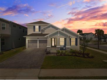 Charming two-story home with a well-manicured lawn, a two-car garage, and colorful sunset at 19283 Allium Pl, Orlando, FL 32827