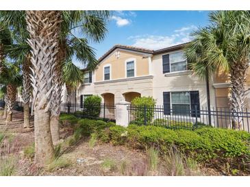 Charming townhome with a beautiful exterior, well-manicured landscaping, and mature palm trees at 1995 Majorca Dr, Kissimmee, FL 34747