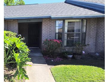 Charming brick home featuring a well-manicured lawn and vibrant landscaping at 2781 King Oak Cir, St Cloud, FL 34769