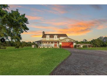 Charming two-story home featuring a brick driveway, large front lawn, and a welcoming front porch at 3255 Tucker Ave, St Cloud, FL 34772