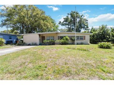 Charming single-story home with a well-manicured front yard, mature trees, and classic architectural details at 3503 S Crystal Lake Dr, Orlando, FL 32806