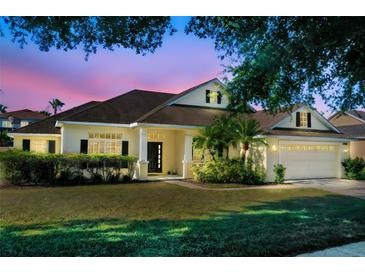Inviting home with a well-manicured lawn, lush landscaping, and a charming front entrance at twilight at 506 Alleria Ct, Auburndale, FL 33823