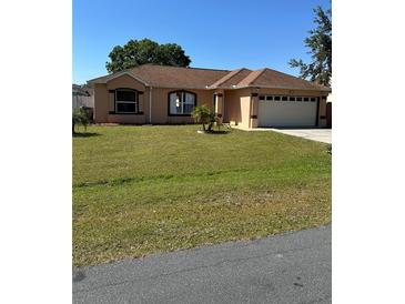 Charming single-story home with a well-manicured lawn, two-car garage, and a neatly landscaped yard at 804 Carrousel Ln, Kissimmee, FL 34759