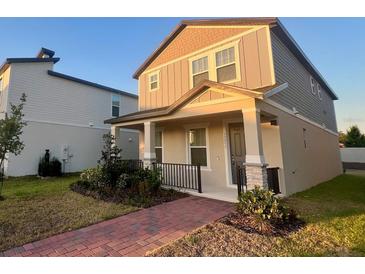 Charming two-story home featuring a welcoming front porch, landscaped yard, and neutral color palette at 12253 S Bracco St, Winter Garden, FL 34787