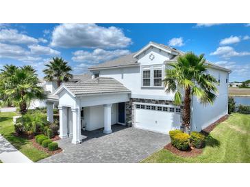 Beautiful two-story home featuring a stone-accented facade, well-manicured lawn, and a two-car garage at 1443 Bunker Dr, Davenport, FL 33836