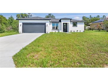 Well-maintained, modern home with a spacious front yard and attached garage at 2437 Sw 147Th Ln, Ocala, FL 34473