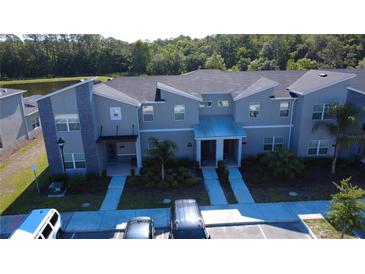 Newer construction townhouse with gray tones, manicured landscaping, and ample parking at 2605 Reading Trl, Kissimmee, FL 34746