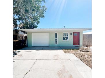 Charming single-story home featuring a red door, garage and well-maintained lawn at 3208 Timberline Road, Winter Haven, FL 33880