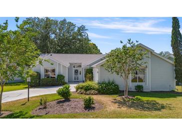 Charming single-story home featuring lush landscaping, a well-manicured lawn, and a welcoming entrance at 508 Alcazar Ct, The Villages, FL 32159