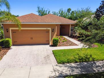 Charming single-story home with a well-manicured lawn and two-car garage at 523 Shell Creek St, Poinciana, FL 34759