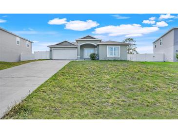 Charming single-story home featuring a well-maintained lawn and attached two-car garage at 53 Zinnia E Ln, Kissimmee, FL 34759