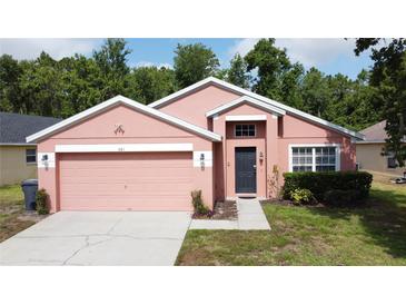 Charming single-story home features a two-car garage and well-manicured lawn at 661 Sandy Ridge Dr, Davenport, FL 33896