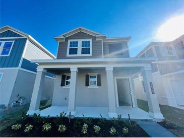 Charming two-story home featuring a covered front porch with stately columns and low-maintenance landscaping at 8023 Sayings Dr, Winter Garden, FL 34787