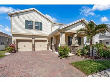 Charming two-story home featuring a paver driveway, attached two-car garage, and nicely landscaped front yard at 9056 Pinch Shot Dr, Winter Garden, FL 34787