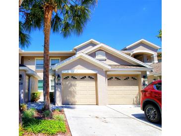Inviting townhome featuring a two-car garage, lush landscaping, and a well-maintained facade, perfect for comfortable living at 9435 Myrtle Creek Ln # 304, Orlando, FL 32832