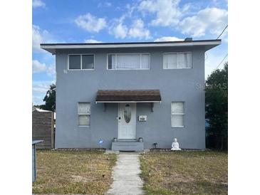 Two-story home featuring windows, front door with a Buddha statue and a well-maintained lawn at 130 Avenue H Se, Winter Haven, FL 33880