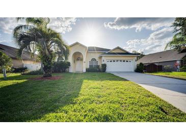 Inviting single-story home with a well-manicured lawn and mature palm tree in a sunny setting at 624 Montana Ave, Davenport, FL 33897