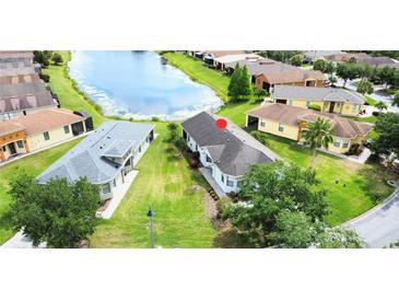 An aerial view showcases this home's prime location near a serene lake and lush green surroundings at 817 Grand Canal Dr, Kissimmee, FL 34759