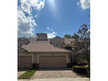 Beuatiful home exterior with two car garage, a tile roof, and well maintained landscaping at 8369 Riverdale Ln # 1, Davenport, FL 33896