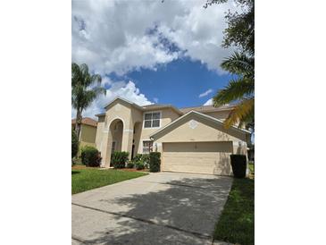 Two-story home featuring a two-car garage, arched entryway, and a well-maintained lawn at 1960 Aspenridge Ct, Ocoee, FL 34761