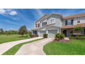 Charming townhome featuring a well-manicured lawn and a two-car garage at 2462 Hassonite St, Kissimmee, FL 34744
