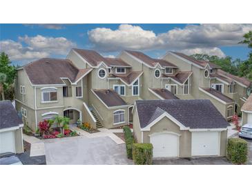 A multi-Gathering home boasts charming curb appeal with colorful landscaping and private garages at 2662 Emerald Lake Ct, Kissimmee, FL 34744