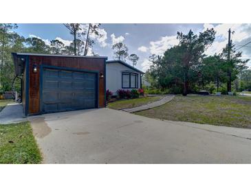 Exterior features a modern home with a gray two-car garage and a concrete driveway at 3669 General Marshall Rd, Daytona Beach, FL 32124
