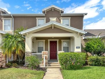 Charming townhome featuring a welcoming front porch and a neatly landscaped yard at 4909 Terrapin Blvd, St Cloud, FL 34771