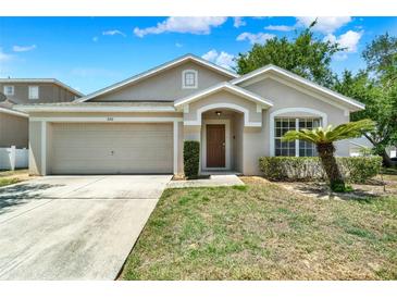 Charming single-story home with a well-manicured lawn and an attached two-car garage at 550 Castlemain Cir, Davenport, FL 33897