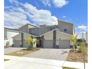Contemporary townhomes featuring modern architectural design and attached garages at 637 Ocean Course Ave, Davenport, FL 33896