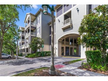 Beautiful condo building with a covered parking area entrance and mature landscaping at 650 Campus St # 309, Celebration, FL 34747