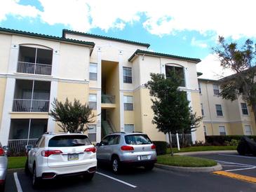 Condo building with multiple parking spaces and view of sky at 8809 Dunes Ct # 201, Kissimmee, FL 34747