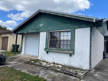 Charming one-story home featuring green trim, a garage, and a well-lit window at 930 Buttercup Dr, Lakeland, FL 33801