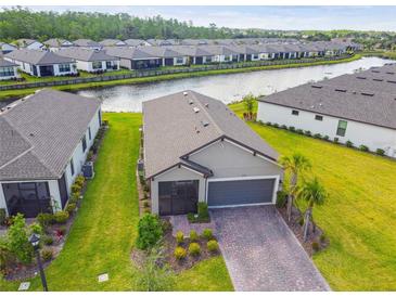 Stunning aerial view of home on a waterfront lot showcasing the beautiful landscaping and proximity to community amenities at 1014 Umbria Dr, Kissimmee, FL 34759