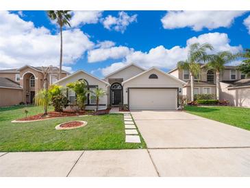 Charming single-story home with well-manicured lawn, inviting entrance, and a two car garage at 153 Pine Isle Dr, Sanford, FL 32773